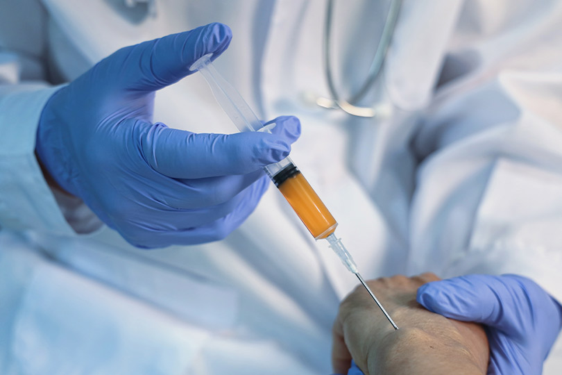 A healthcare professional gives an injection to a patient, showcasing the role of generative medicine in treatment.