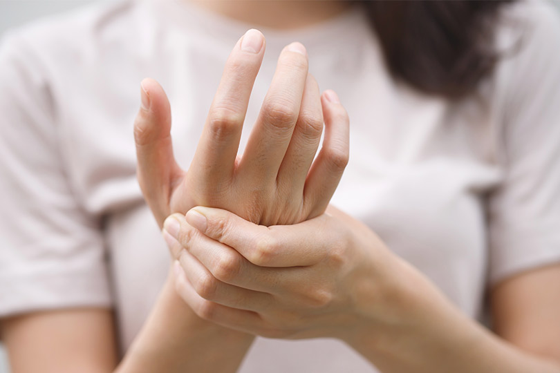 A woman resting her chin on her hands, representing Mission's top pain management specialists.
