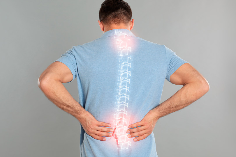 A man grimacing while holding his back, representing back pain, alongside a guide to pain management in RGV.