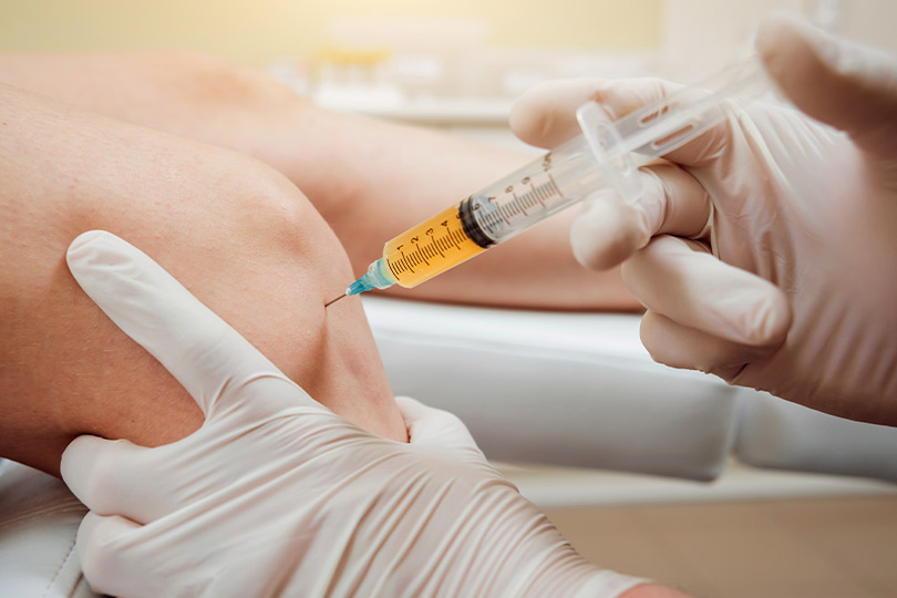 A doctor administering an injection to a patient for rheumatoid arthritis treatment.
