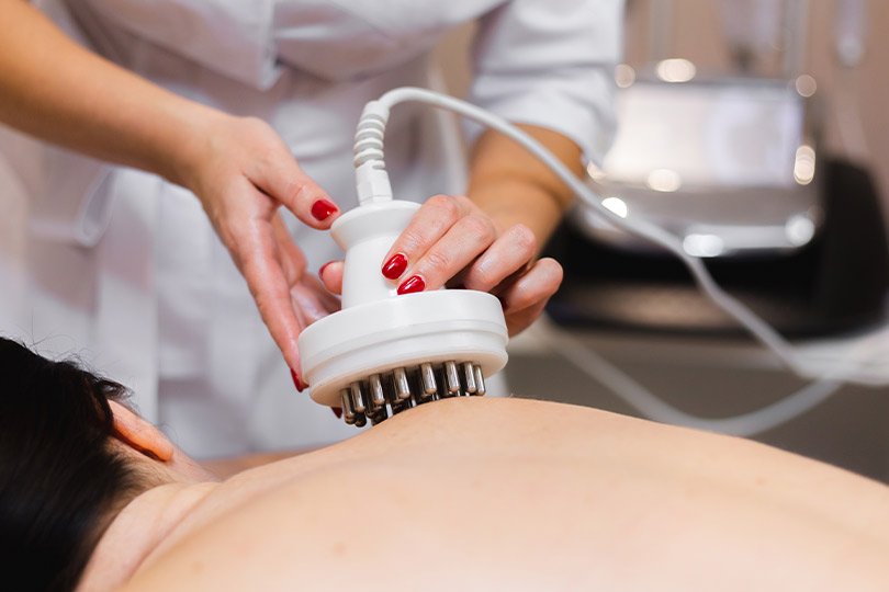 A woman receiving a massage while a hair dryer is used, illustrating a unique approach to rheumatoid arthritis treatment.